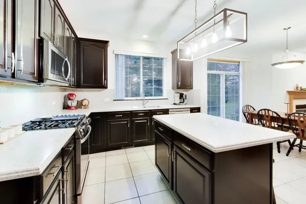 a kitchen with a stove a sink a refrigerator and a microwave