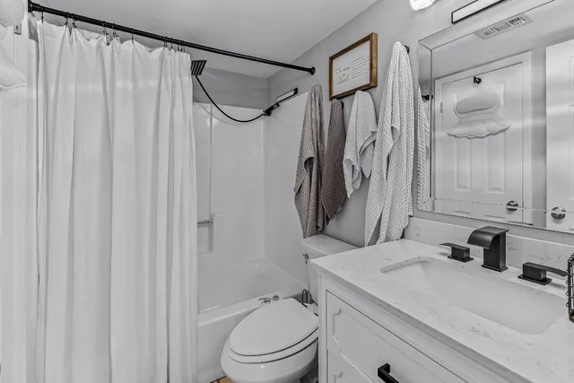 a bathroom with a granite countertop sink toilet and shower