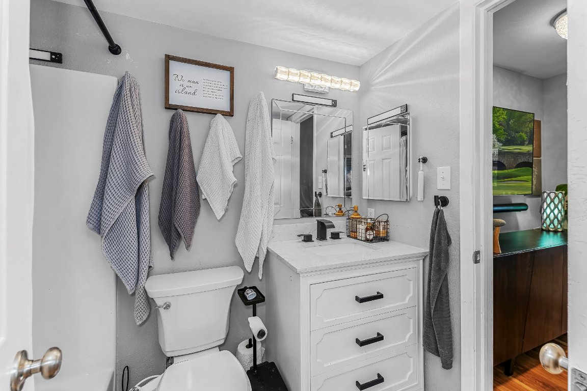 2500 Burleson Road, Unit 621 Austin, TX 78741 - Photo 14 of 26 a bathroom with a sink vanity mirror and toilet