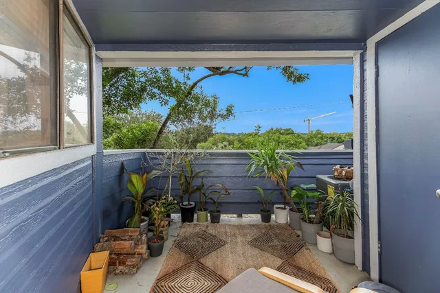 a view of a porch with chairs and potted plants