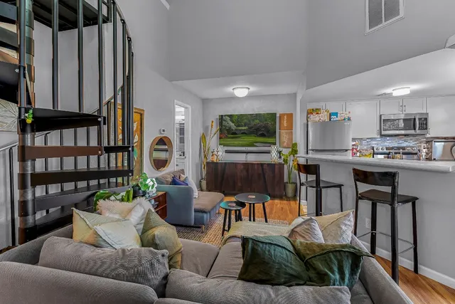 a living room with furniture kitchen view and a flat screen tv