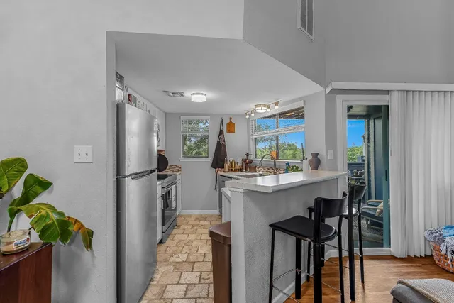 a kitchen with kitchen island a refrigerator a stove a sink and a dining table