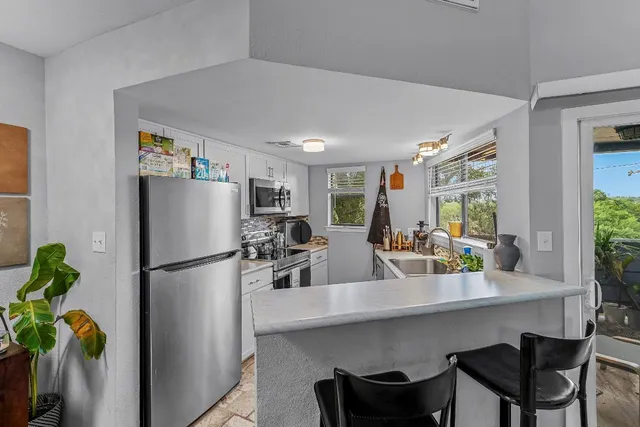 a kitchen with refrigerator and table