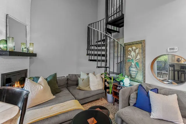a living room with furniture a fireplace and a potted plant