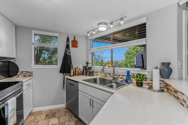 a kitchen with sink refrigerator and window