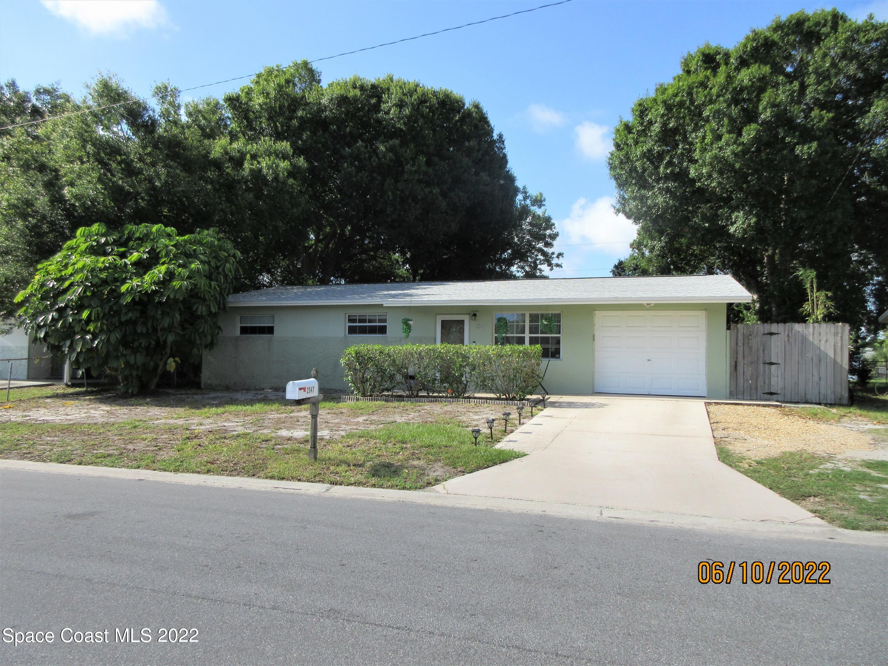 2547 Locksley Road Melbourne, FL 32935 - Photo 1 of 28 a front view of a house with a yard and garage