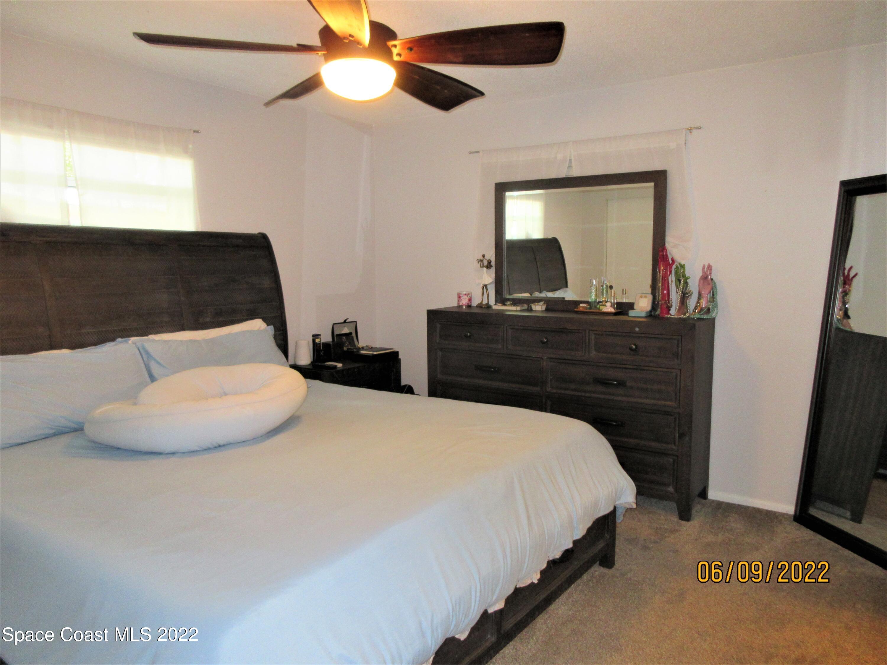 2547 Locksley Road Melbourne, FL 32935 - Photo 14 of 28 a bedroom with a bed and a chandelier