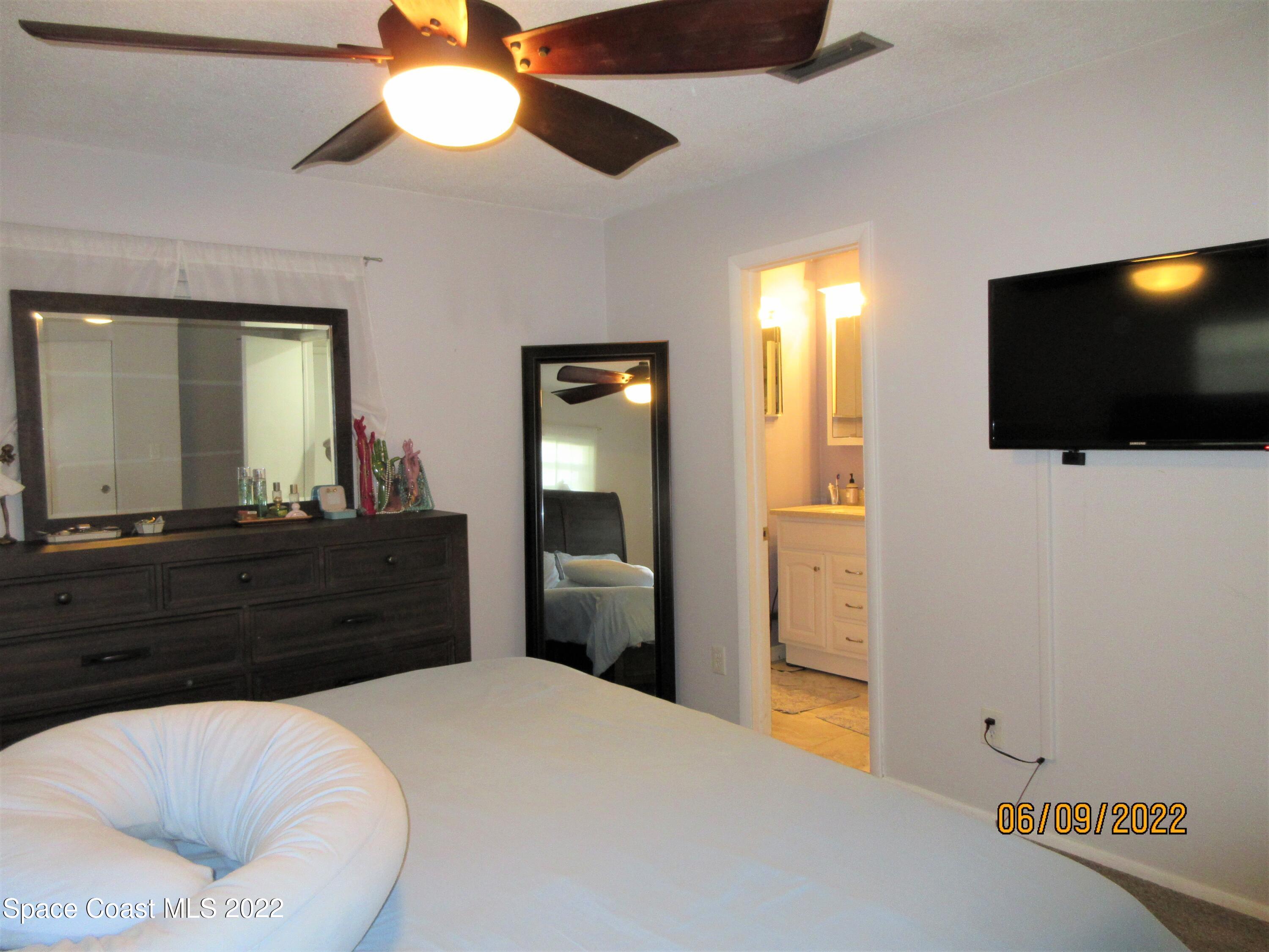 2547 Locksley Road Melbourne, FL 32935 - Photo 15 of 28 a room with a bed and a flat screen tv