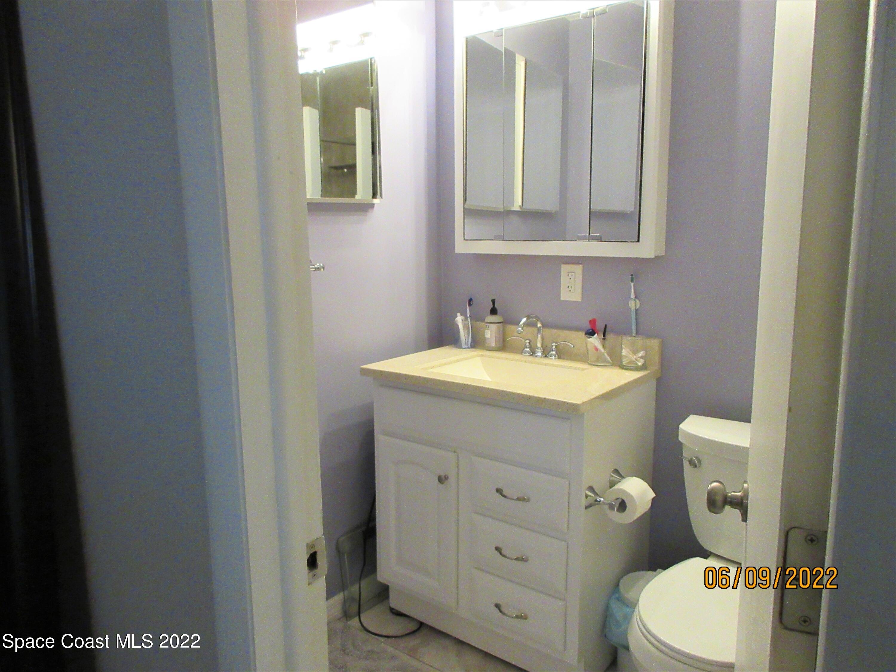2547 Locksley Road Melbourne, FL 32935 - Photo 16 of 28 a bathroom with a toilet a sink and mirror