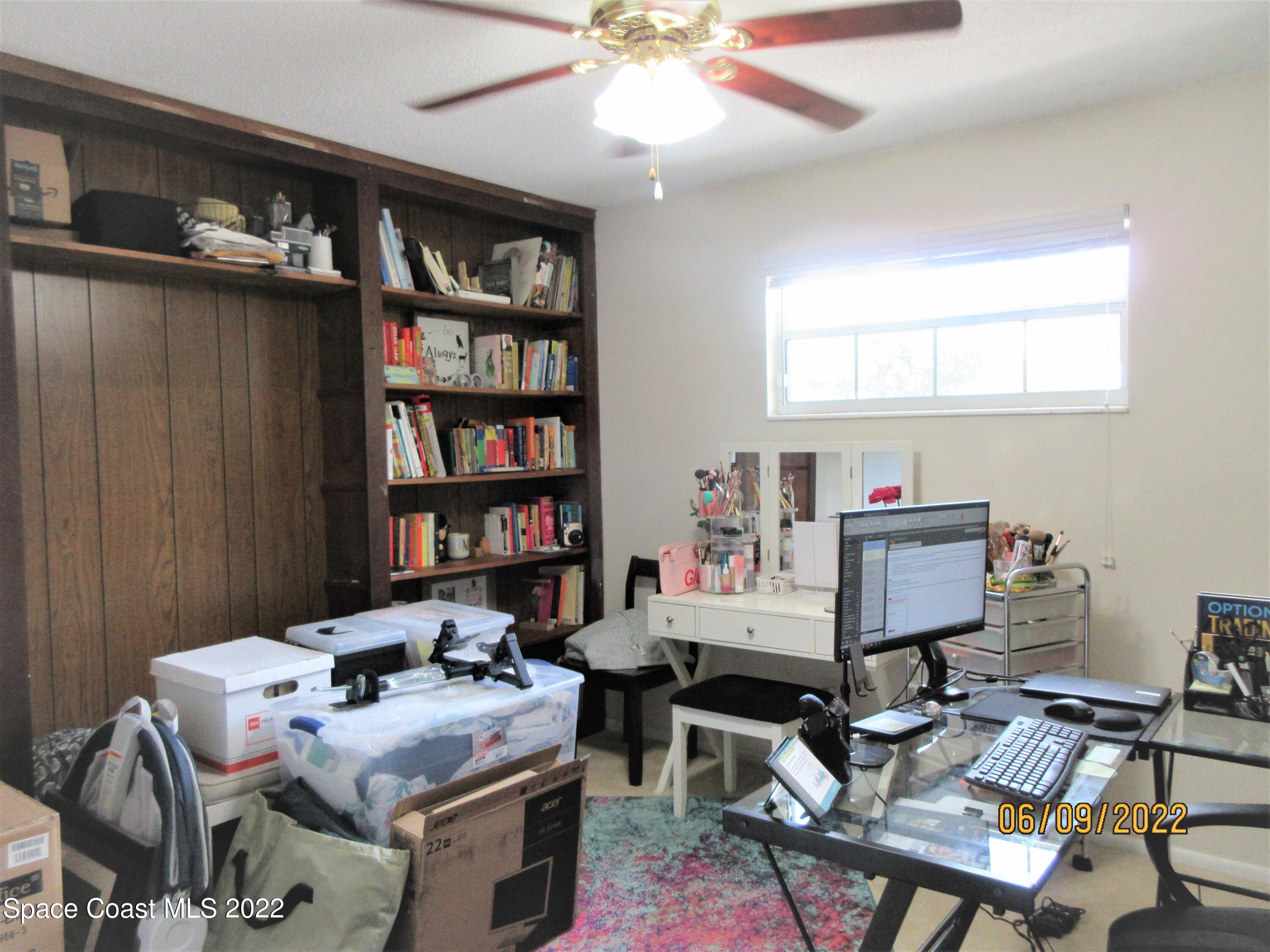 2547 Locksley Road Melbourne, FL 32935 - Photo 19 of 28 a room with furniture and a book shelf