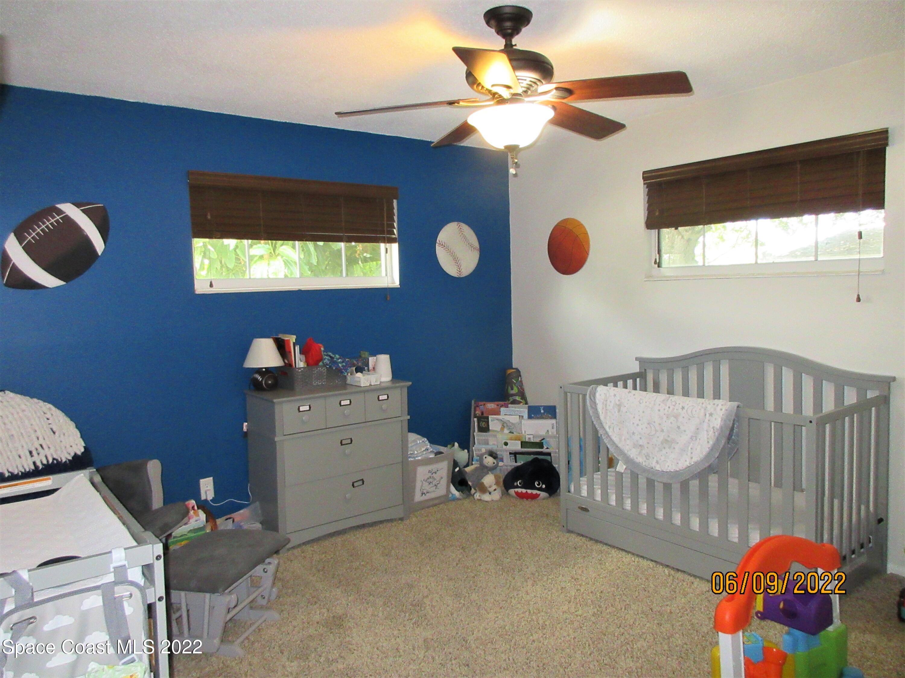 2547 Locksley Road Melbourne, FL 32935 - Photo 21 of 28 a bedroom with a bed and a chandelier