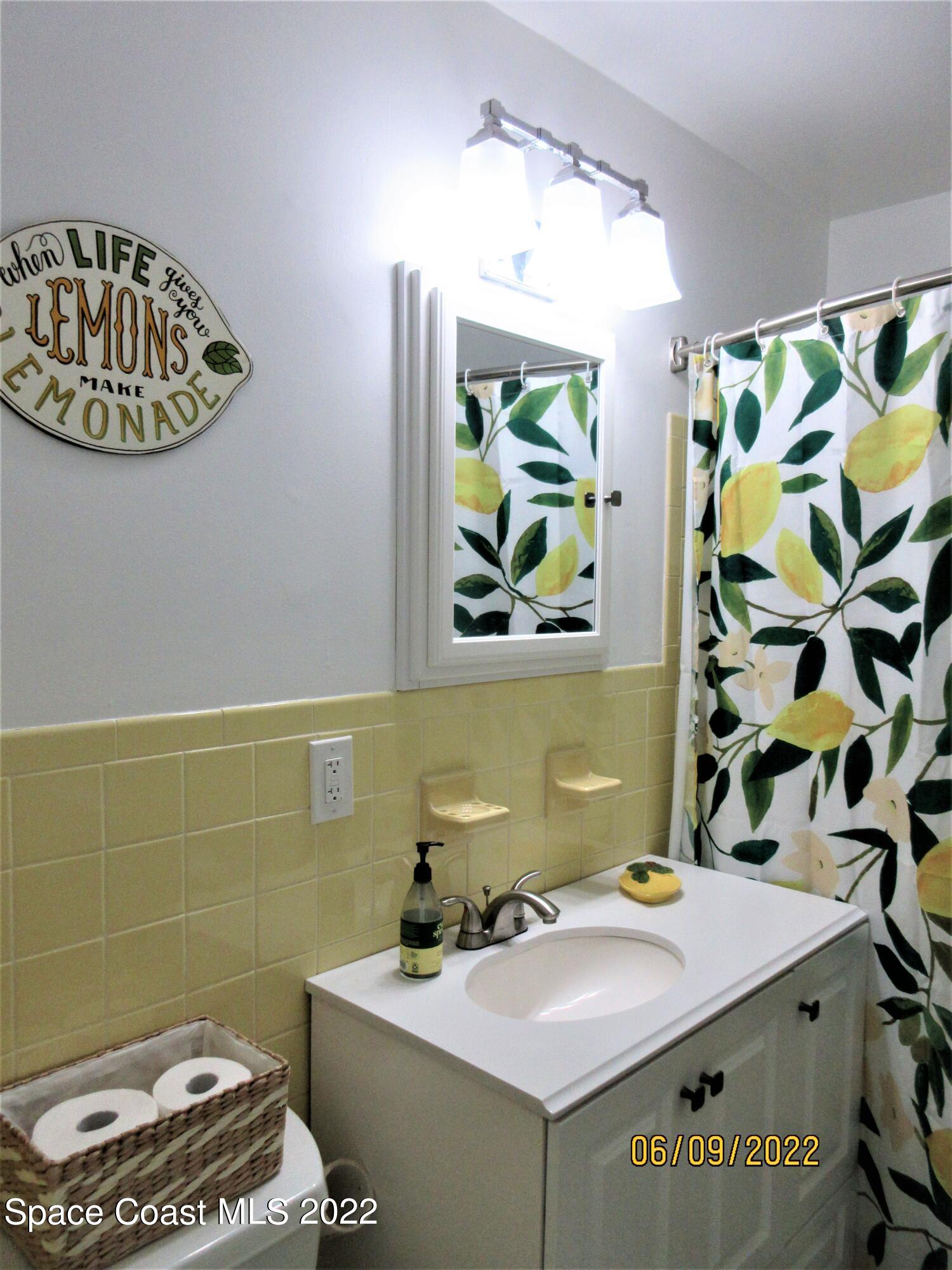 2547 Locksley Road Melbourne, FL 32935 - Photo 22 of 28 a bathroom with a sink a toilet and a mirror