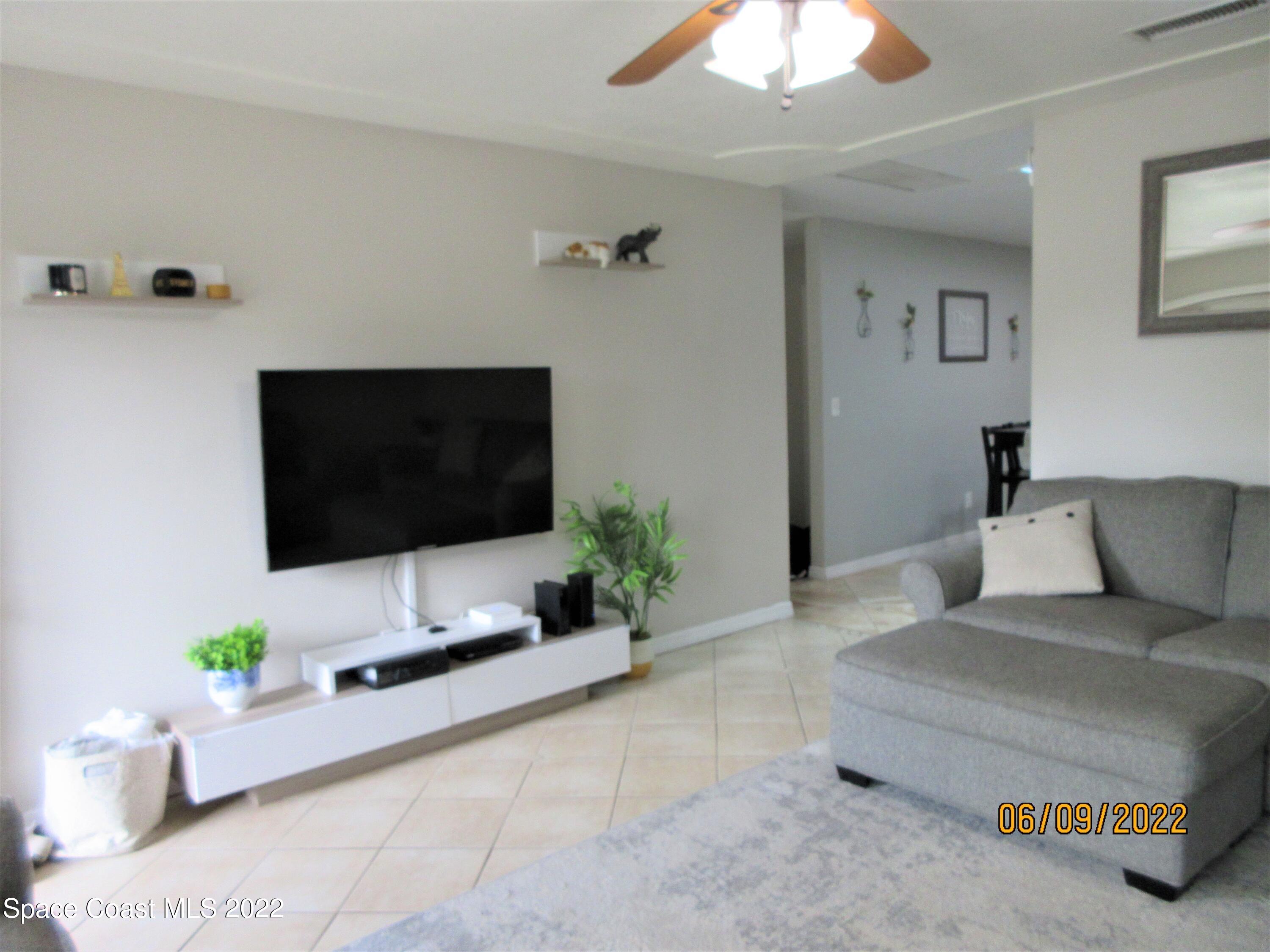 2547 Locksley Road Melbourne, FL 32935 - Photo 4 of 28 a living room with furniture and a flat screen tv