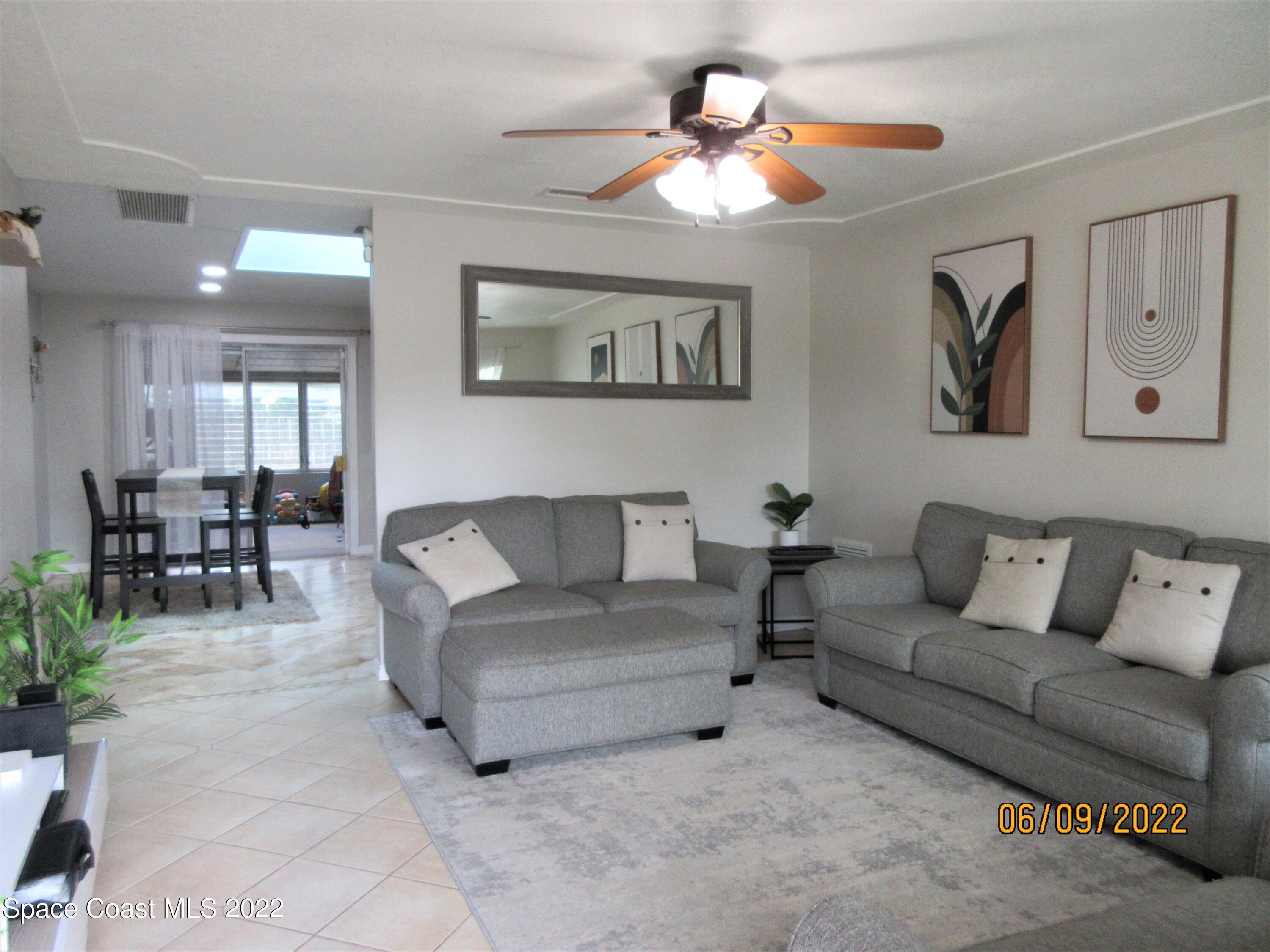 2547 Locksley Road Melbourne, FL 32935 - Photo 5 of 28 a living room with furniture and a chandelier