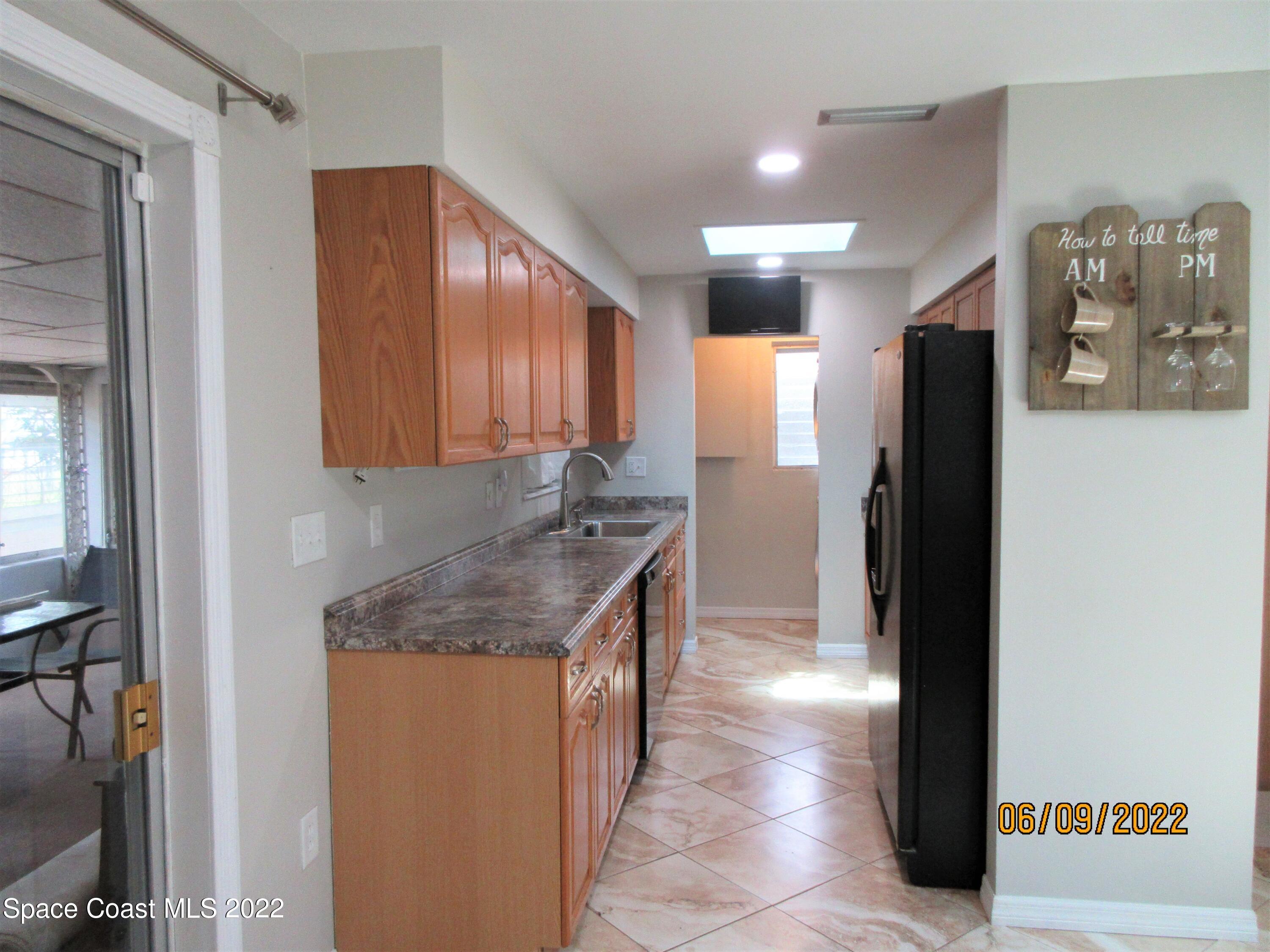 2547 Locksley Road Melbourne, FL 32935 - Photo 8 of 28 a kitchen with stainless steel appliances granite countertop a refrigerator and a sink
