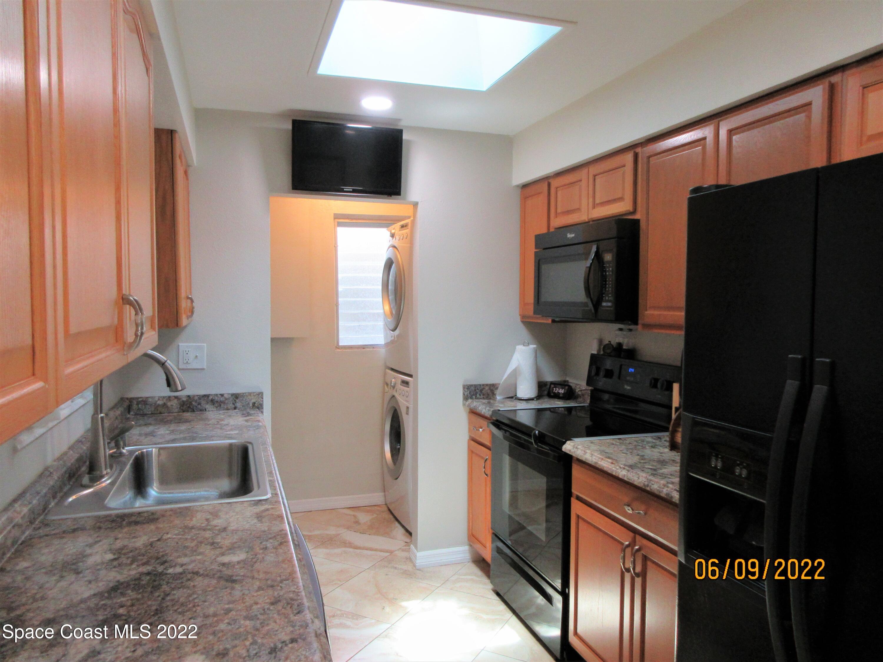 2547 Locksley Road Melbourne, FL 32935 - Photo 9 of 28 a kitchen with a sink a stove and a microwave