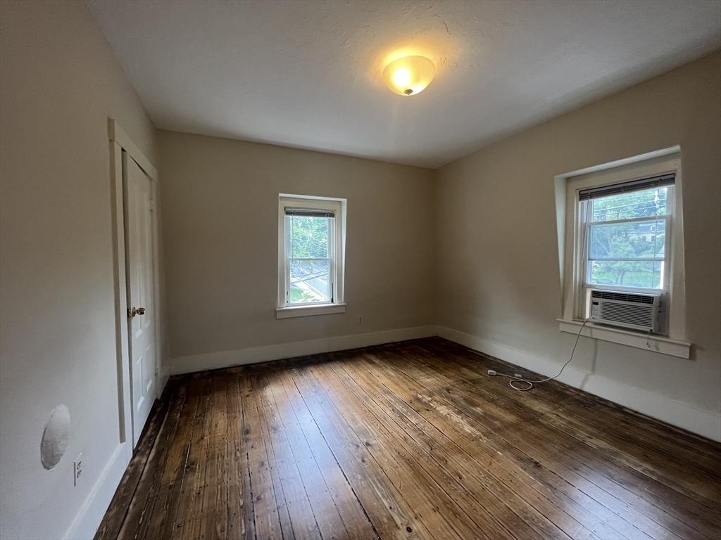 76 Chestnut Street, Unit 2 Newton, MA 02465 - Photo 17 of 21 an empty room with wooden floor and windows