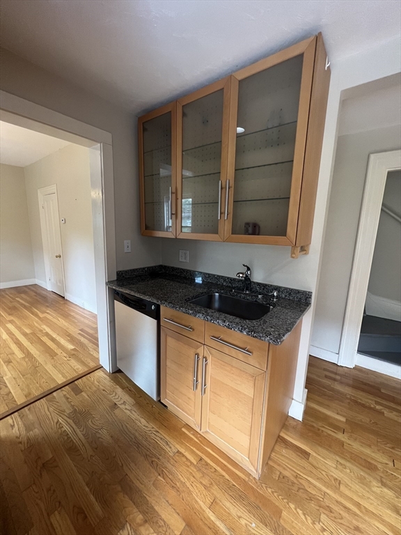 76 Chestnut Street, Unit 2 Newton, MA 02465 - Photo 6 of 21 a kitchen with granite countertop a stove and a wooden floor