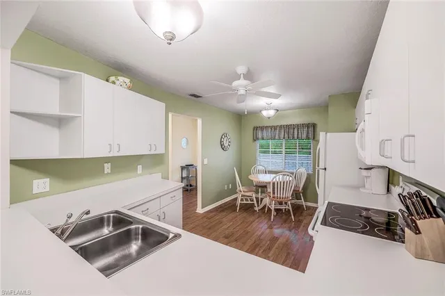 a kitchen with a table chairs and white cabinets