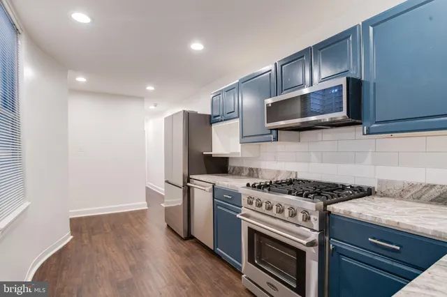 a kitchen with stainless steel appliances granite countertop a stove a microwave and a refrigerator