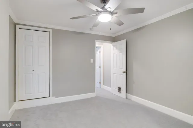 a view of an empty room and chandelier fan