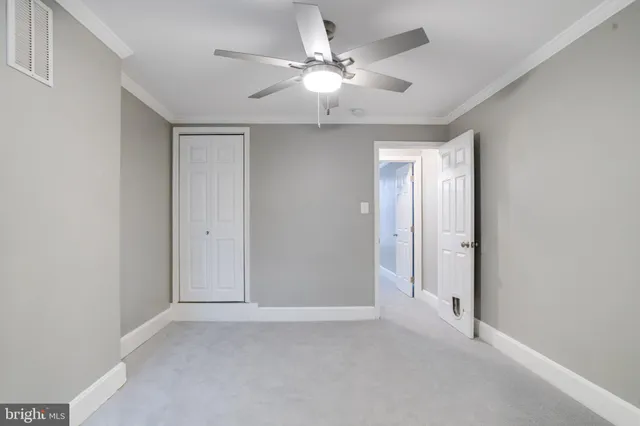 an empty room with chandelier fan