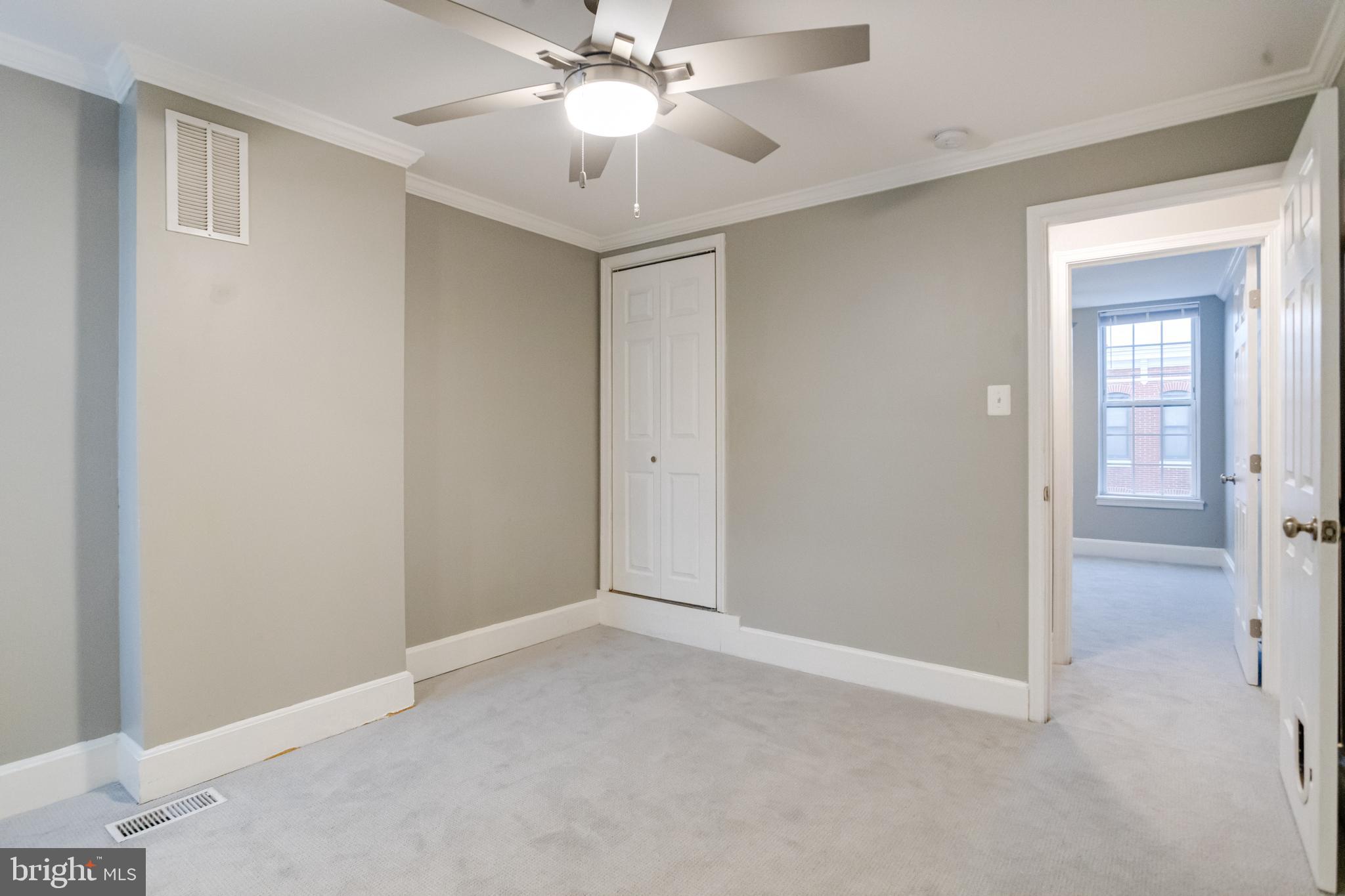 1313 Patapsco Street Baltimore, MD 21230 - Photo 22 of 52 an empty room with a ceiling fan and a bathroom