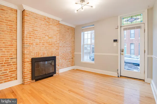 an empty room with windows and fireplace