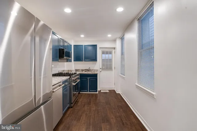 a kitchen with stainless steel appliances granite countertop a refrigerator a stove top oven a sink and dishwasher