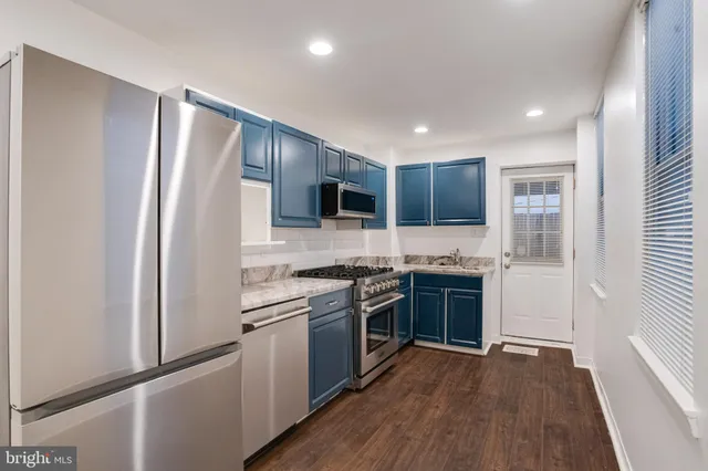 a kitchen with stainless steel appliances granite countertop a refrigerator stove and sink