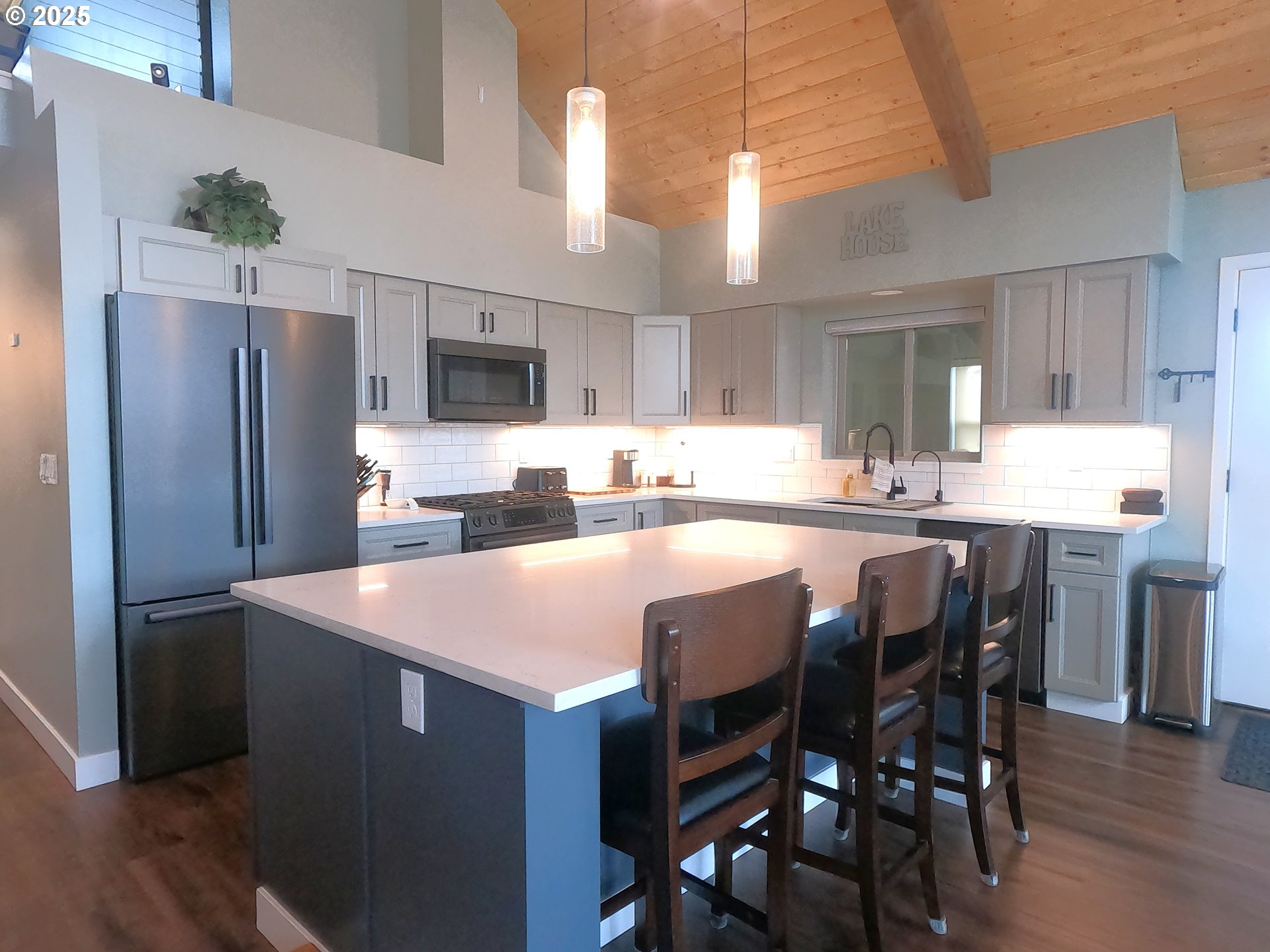 13422 Southwest Airfield Lane Culver, OR 97734 - Photo 11 of 42 a kitchen with stainless steel appliances granite countertop a dining table chairs refrigerator and cabinets