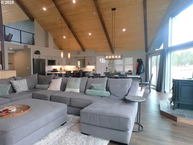 a living room with furniture kitchen and a large window