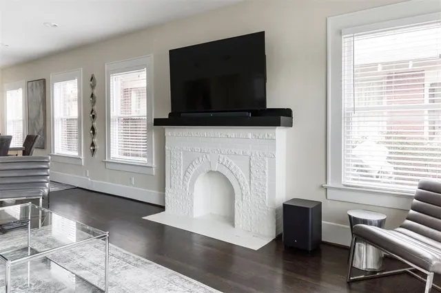 a living room with furniture a flat screen tv and a fireplace