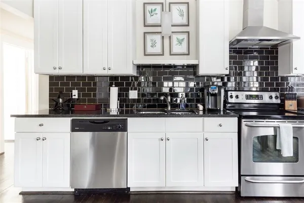 a kitchen with white cabinets and sink