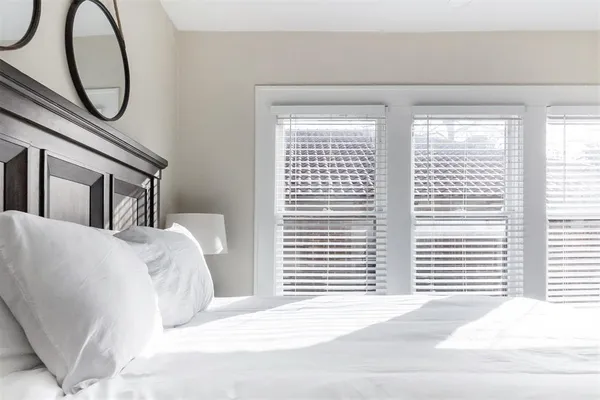 a bedroom with a bed a mirror and a window