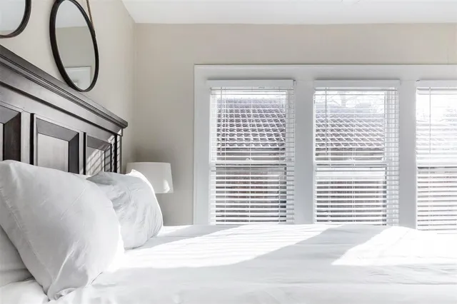 a bedroom with a bed a mirror and a window