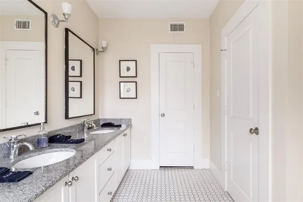 a spacious bathroom with a granite countertop sink a mirror and a shower