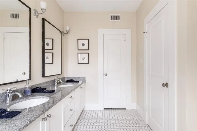 a spacious bathroom with a granite countertop sink a mirror and a shower