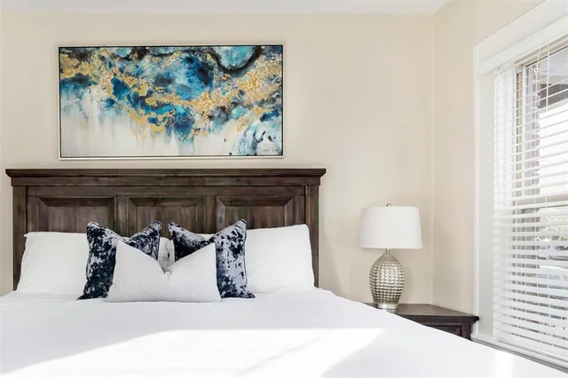 a bedroom with a bed and a painting on the wall
