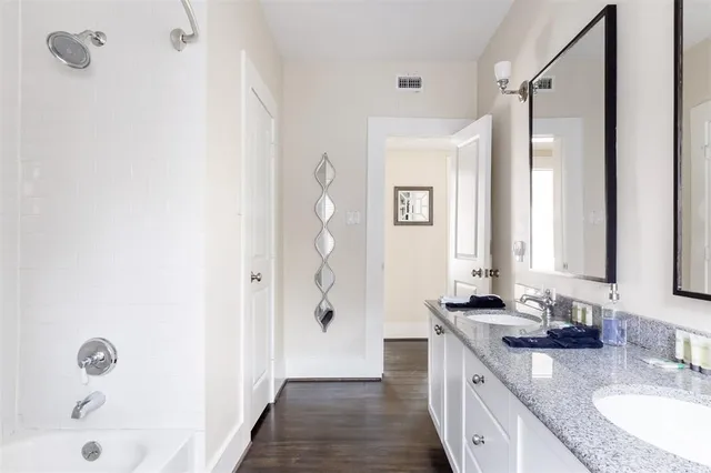 a bathroom with a granite countertop sink a mirror and a shower