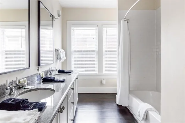 a bathroom with a granite countertop tub sink and mirror
