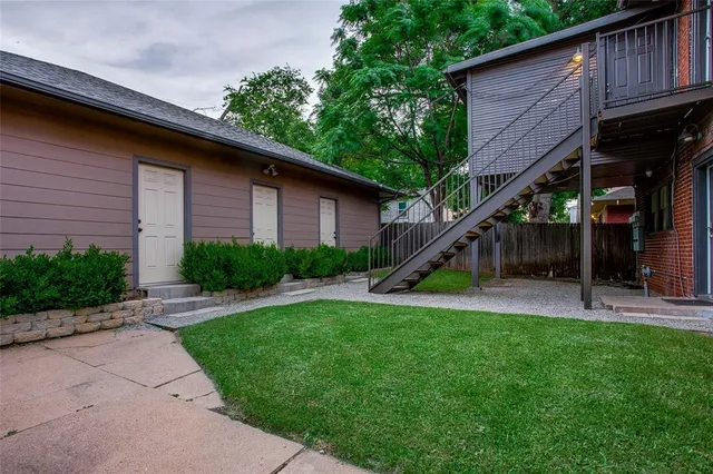 a view of a house with backyard and a tree