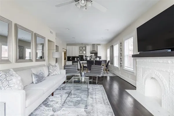 a living room with furniture a flat screen tv and a fireplace