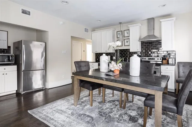 a dining room with stainless steel appliances granite countertop a dining table and chairs