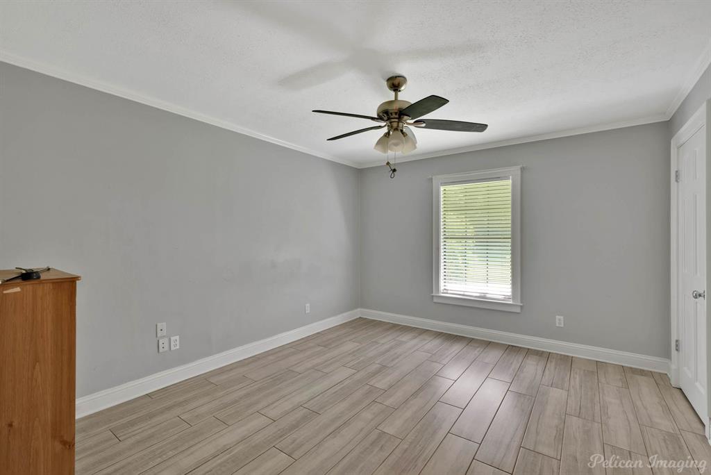 8344 Odom Road Greenwood, LA 71033 - Photo 19 of 39 Spare room featuring wood finished floors, a ceiling fan, ornamental molding, and a textured ceiling
