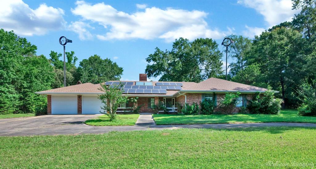 8344 Odom Road Greenwood, LA 71033 - Photo 2 of 39 Ranch-style home with driveway, brick siding, an attached garage, and solar panels