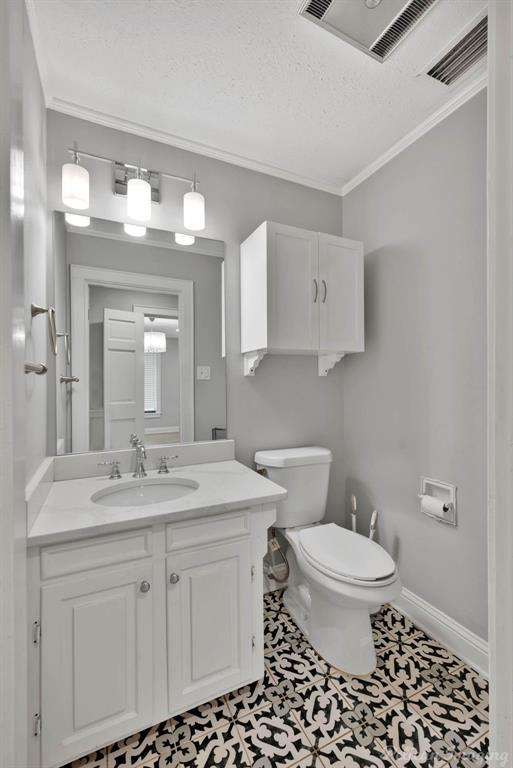 8344 Odom Road Greenwood, LA 71033 - Photo 23 of 39 Bathroom featuring vanity, crown molding, and a textured ceiling