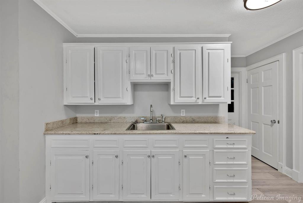 8344 Odom Road Greenwood, LA 71033 - Photo 27 of 39 Kitchen with white cabinets, crown molding, and light wood-style flooring