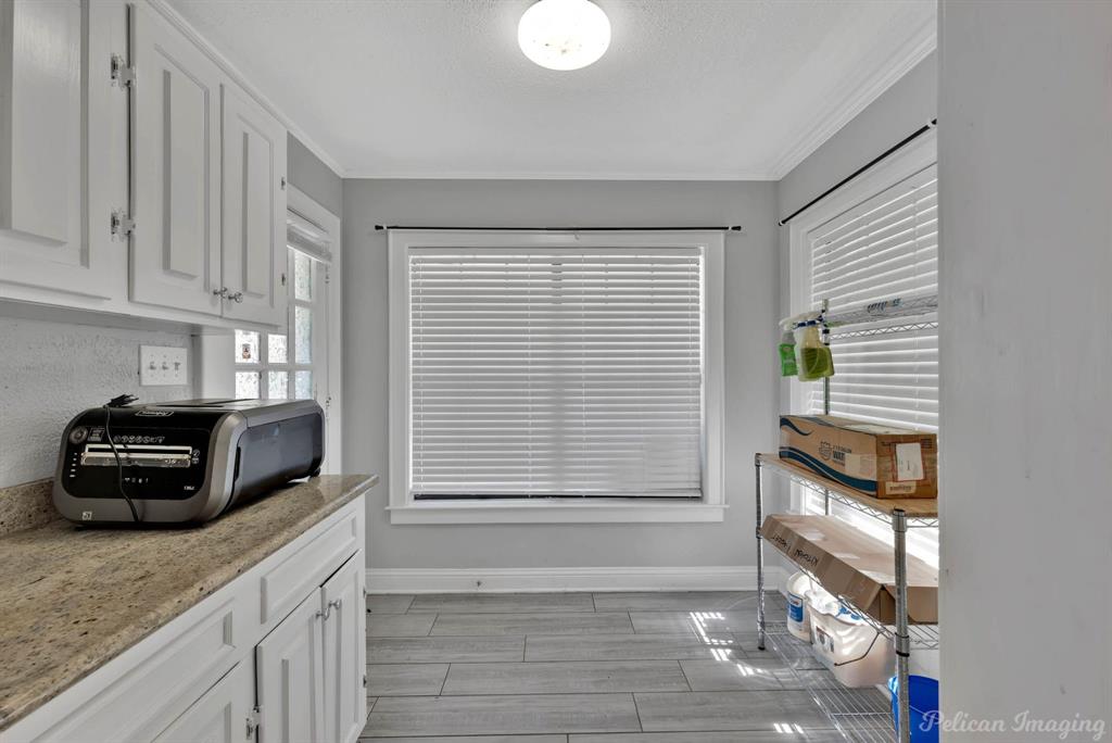 8344 Odom Road Greenwood, LA 71033 - Photo 28 of 39 Kitchen with white cabinets, ornamental molding, and light stone counters