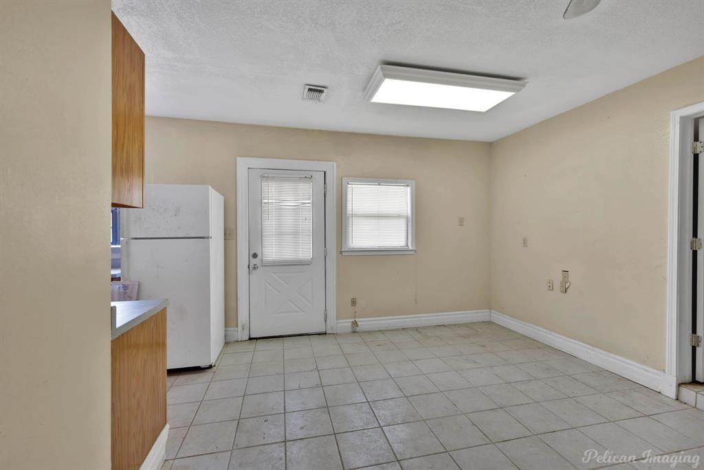 8344 Odom Road Greenwood, LA 71033 - Photo 31 of 39 Guest house - Kitchen featuring freestanding refrigerator, a textured ceiling, light tile patterned floors, and light countertops